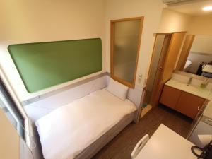 een kleine kamer met een bed en een groene muur bij ColorMix Hotel & Hostel in Taipei