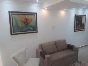 uma sala de estar com um sofá e pinturas na parede em Unidade Executiva Luxo 33m² em Brasília