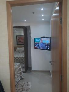 um quarto com uma televisão numa parede com uma cama em Unidade Executiva Luxo 33m² em Brasília