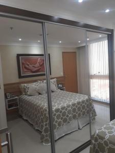 a bedroom with a bed and a large mirror at Unidade Executiva Luxo 33m² in Brasilia