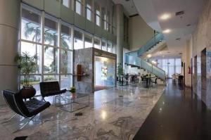 a lobby with chairs and a staircase in a building at Unidade Executiva Luxo 33m² in Brasilia