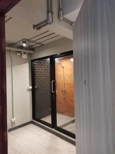 a room with a glass door and a brick wall at BED STATION Hostel Khaosan in Bangkok