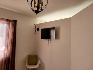 a room with a tv on the wall and a chair at Departamento UNIVERSITARIO en fraccionamiento privado in Chihuahua