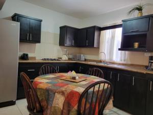 a kitchen with a table and chairs and a kitchen with black cabinets at Departamento UNIVERSITARIO en fraccionamiento privado in Chihuahua