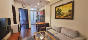 a living room with a couch and a table at Ruby Serviced Apartment Liễu Giai in Hanoi