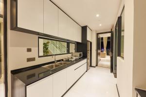 a kitchen with white cabinets and a sink at Luxcity Hotel & Apartment in Phnom Penh