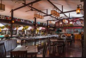a restaurant with tables and chairs and a bar at Shah's Beach Resort Melaka in Melaka