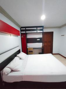 a bedroom with a large white bed in a room at Hotel Riverside Manado in Manado