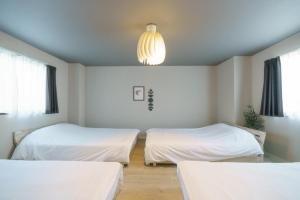 Habitación con 2 camas y lámpara de araña. en 自由自在OSU 302(TORI), en Nagoya