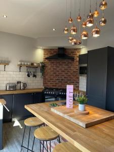 a kitchen with a large wooden table with stools at Town center cottage with Hot tub in Morpeth
