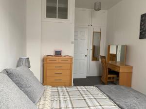 a bedroom with a bed and a desk and a table at Historic Picturesque Apartment Pembroke in Pembrokeshire