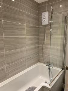 a bathroom with a shower with a tub and a sink at Historic Picturesque Apartment Pembroke in Pembrokeshire