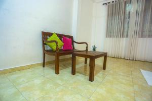 a wooden bench with pink and green pillows on it at Villa 382 in Galle