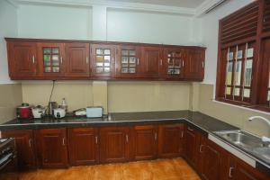 a kitchen with wooden cabinets and a sink at Villa 382 in Galle
