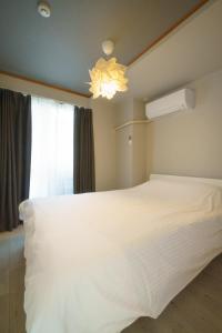 een slaapkamer met een groot wit bed en een raam bij 自由自在OSU 301(KAZE) in Nagoya