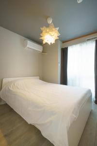 a bedroom with a large white bed and a window at 自由自在OSU 301(KAZE) in Nagoya