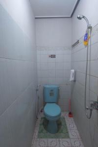 een badkamer met een blauw toilet en een douche bij SIMPANG 7 RESIDENCE in Kudus