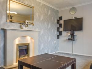 a living room with a tv and a fireplace at Briar Cottage in Knaresborough