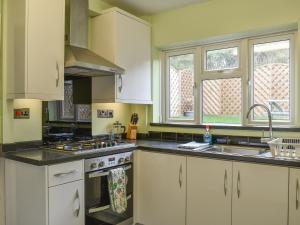 a kitchen with white cabinets and a sink at Briar Cottage in Knaresborough