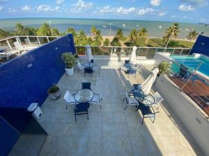 - un balcon avec des chaises, une piscine et l'océan dans l'établissement Tambaú Home Beira Mar - com varanda, à João Pessoa