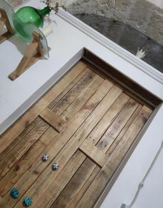 un pavimento in legno nell'angolo di una camera di Kryptàdion a Grottaglie