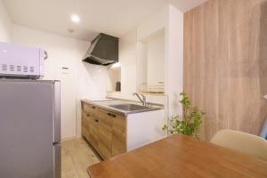 a small kitchen with a sink and a refrigerator at 自由自在OSU 202(UMI) in Nagoya