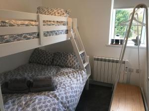 a bedroom with two bunk beds and a bed at Clock Tower Cottage in Whitchurch