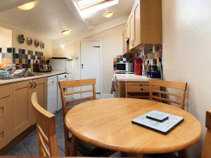 a kitchen with a wooden table and chairs in a kitchen at Grooms Bothy in Bellingham