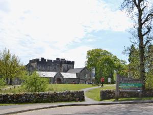 un castillo en una colina con un cartel delante en Grooms Bothy, en Bellingham