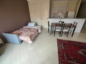 Tuggeranong的住宿－Tuggeranong Short Stay #09 Sleeps 4，一间卧室配有一张床,另一间用餐室配有桌子