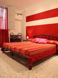 トラーパニにあるCasina delle Palmeの赤い壁のベッドルーム1室(大型ベッド1台付)