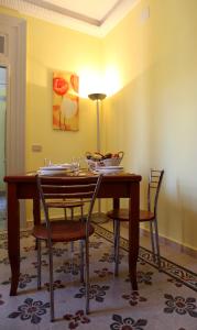 a dining room with a wooden table and chairs at Casina delle Palme in Trapani