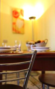a table with a lamp and plates and a chair at Casina delle Palme in Trapani