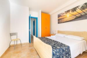 1 dormitorio con 1 cama y 1 silla en Lido Marini Apartments - Happy Rentals, en Salve