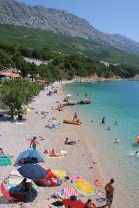 eine Gruppe von Menschen am Strand im Wasser in der Unterkunft Villa Stipe in Lokva Rogoznica