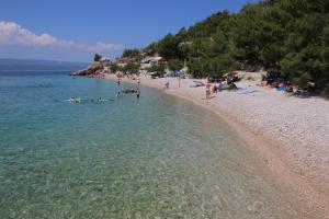 a group of people swimming in the water at a beach at Villa Stipe in Lokva Rogoznica