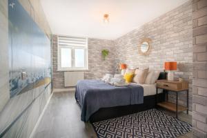 1 dormitorio con cama y pared de ladrillo en Sea View Kemptown Holiday Let, en Brighton & Hove