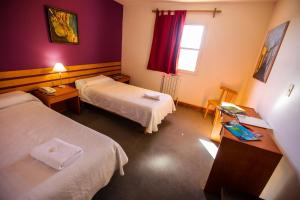 a hotel room with two beds and a window at South B&B El Calafate in El Calafate