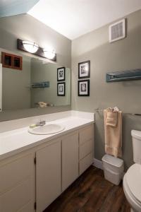 een badkamer met een wastafel, een toilet en een spiegel bij Escape To Ptarmigan Village 6 in Whitefish