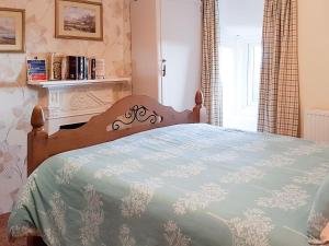 a bedroom with a bed with a blue comforter at Hendy in Llanfaelrhys