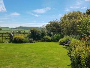 a park bench sitting in a field of grass at Hendy in Llanfaelrhys