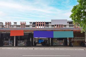 a building with colorful signs on the front of it at SPOT ON 92421 City Kost Syariah in Pangkal Pinang