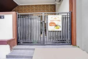 a gate to a building with a sign on it at OYO 92435 Sunlo Cozy Home Family Homestay Syariah in Surabaya
