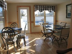 a dining room with a glass table and chairs at Mackenzie Motel & Cottages in Shelburne