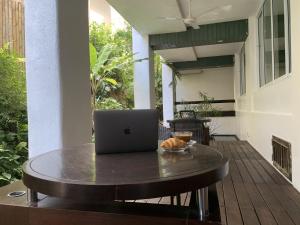 a laptop computer sitting on a table on a patio at Ao Nang Colors Hotel - Aonang Beach in Ao Nang Beach