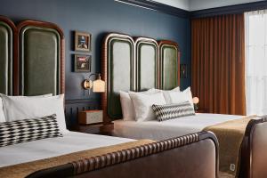 列克星敦的住宿－The Manchester Hotel，蓝色墙壁客房的两张床