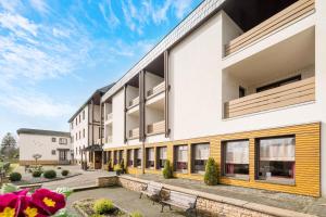 an exterior view of a building with benches at Pension Haus Anny in Deudesfeld