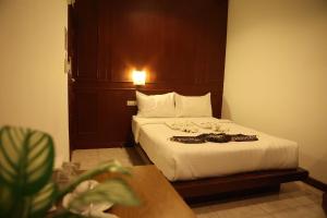 1 dormitorio con 1 cama con cabecero de madera en New Forest Patong, en Patong Beach