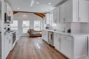 a white kitchen with wooden floors and white cabinets at Hillsboro Village Hideaway in Nashville