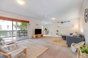 a living room with a couch and a tv at Beach Haven at Alex Heads in Alexandra Headland